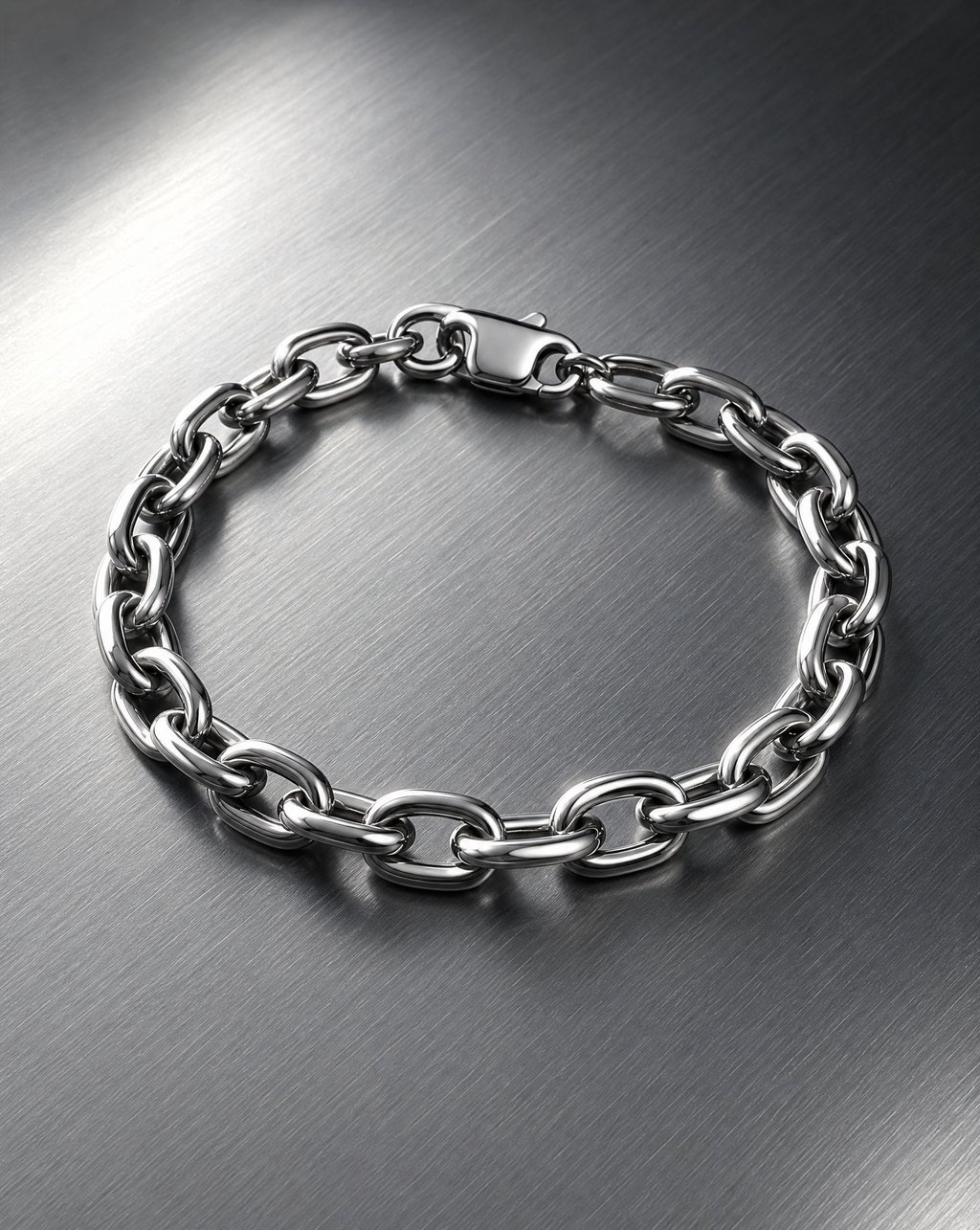 A silver chain bracelet laid on brushed steel under hard light
