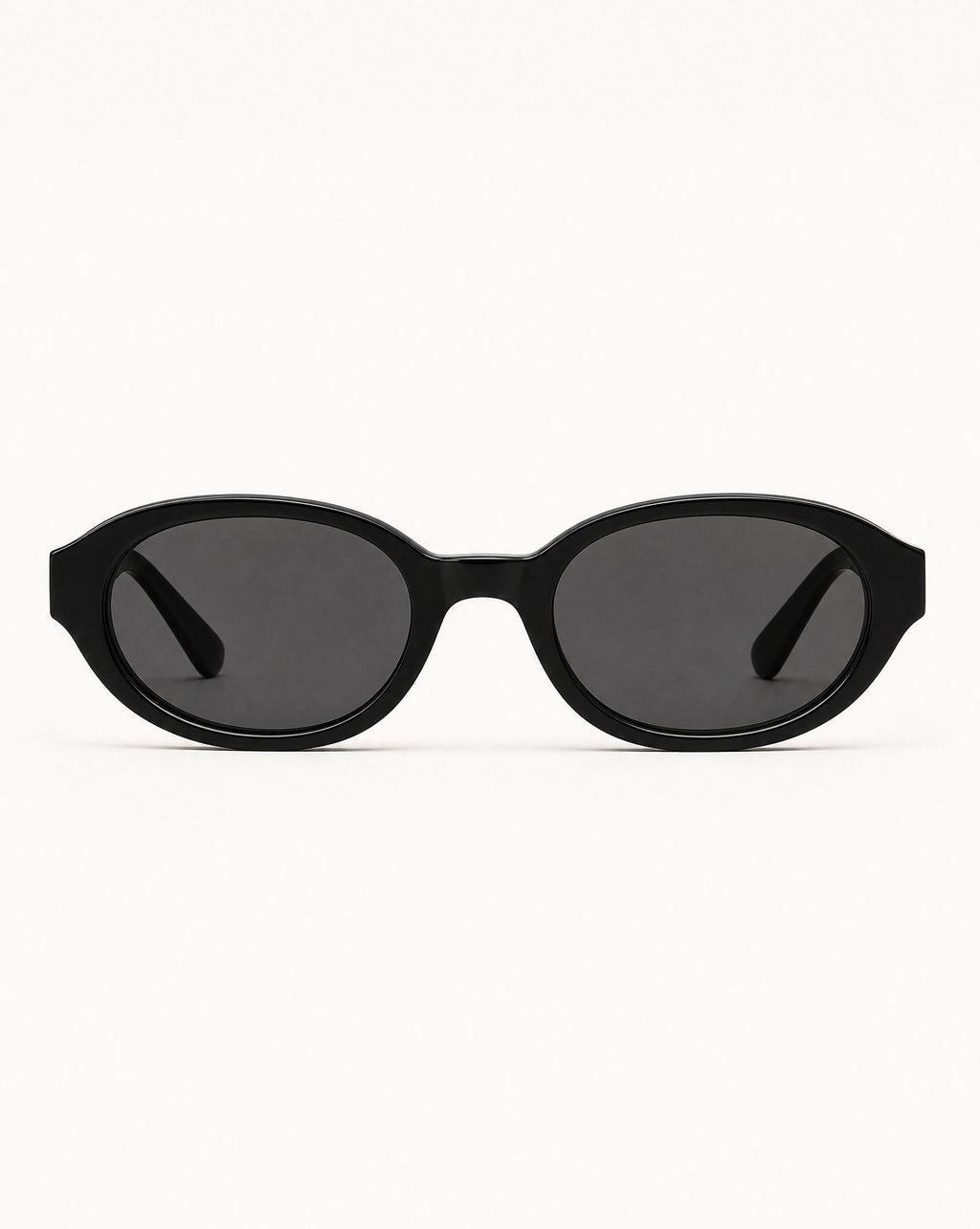 Black sunglasses photographed on a clean pale surface under flat, even lighting