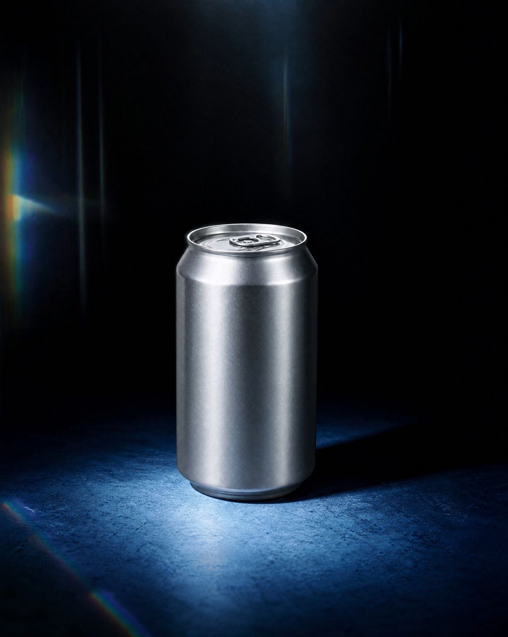 An aluminium can on a dark blue ground under a narrow overhead beam with prismatic flares