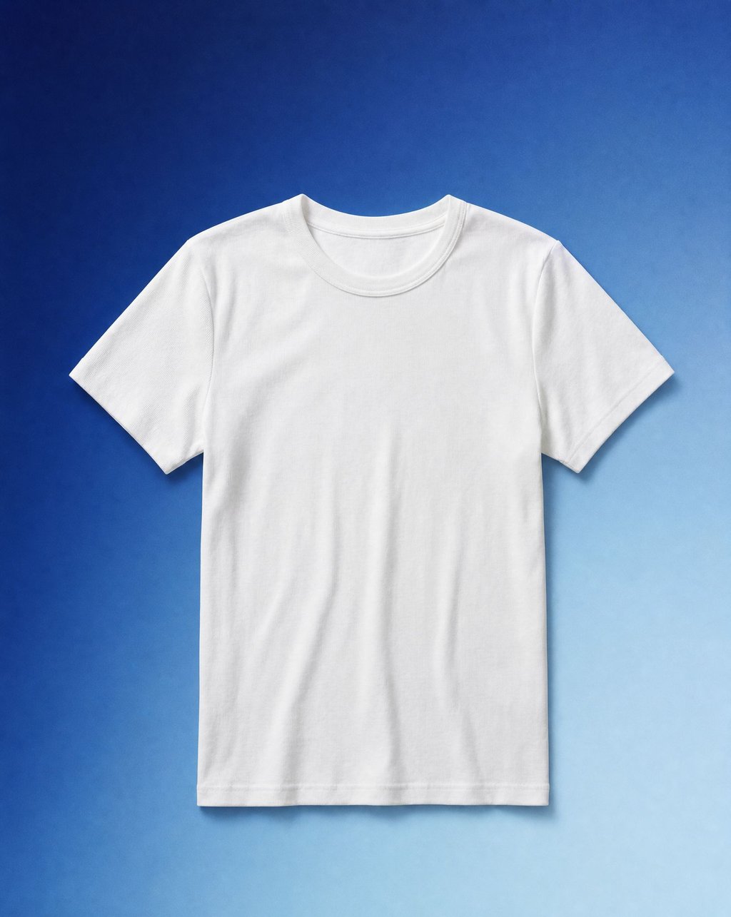 A white t-shirt laid flat on a blue gradient background under soft even light