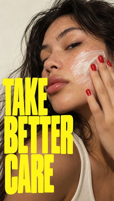 facial cream beauty close-up product photo: A close-up beauty portrait shows a woman smoothing white cream onto her cheek, with red nails and bold yellow displ…