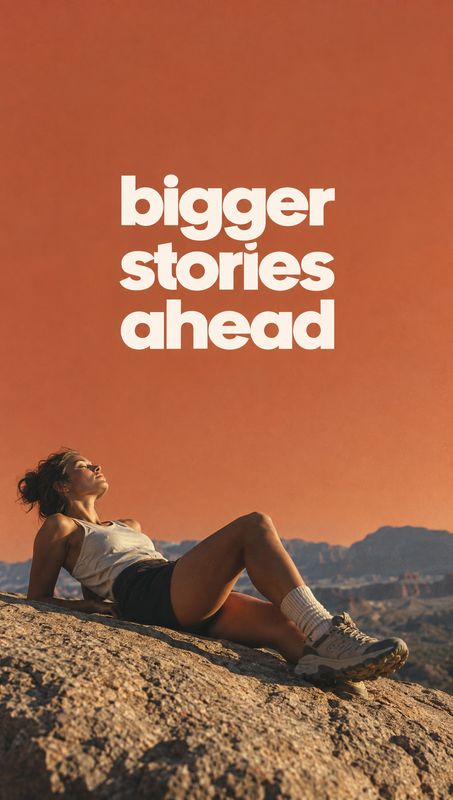 outdoor apparel and sneakers posters product photo: A woman in casual outdoor clothing reclines on a rocky hillside beneath a warm terracotta sky, with bold cr…