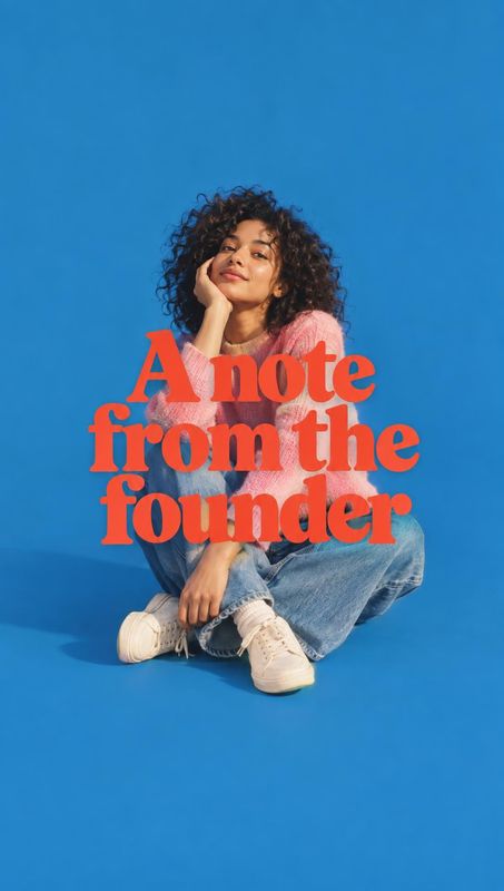 look book product photo: A curly-haired woman in a pink top, loose jeans, and sneakers sits against a vivid blue studio backdrop beneath bold coral headline ty…