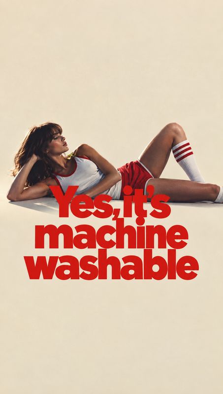 athletic outfit model try-on product photo: A woman in a red-and-white athletic outfit reclines against a warm cream studio backdrop beneath bold red headline…