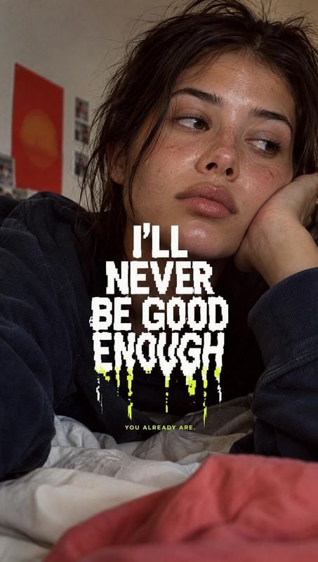 beauty close-up product photo: A close, candid portrait of a young woman resting on a bed in a dim room, overlaid with bold distressed white lettering and neon…