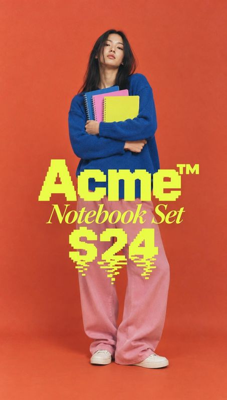 notebook set product in hand product photo: A woman in a vivid blue sweater and loose pink trousers holds colorful notebooks against a saturated orange studio…