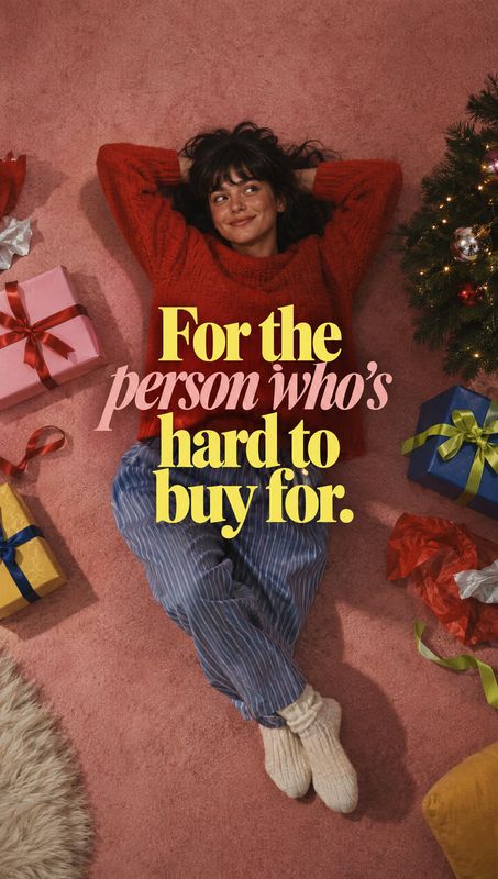 christmas product photo: A woman in a red sweater and striped trousers lounges on a pink carpet among wrapped gifts and a lit Christmas tree, with bold yellow…