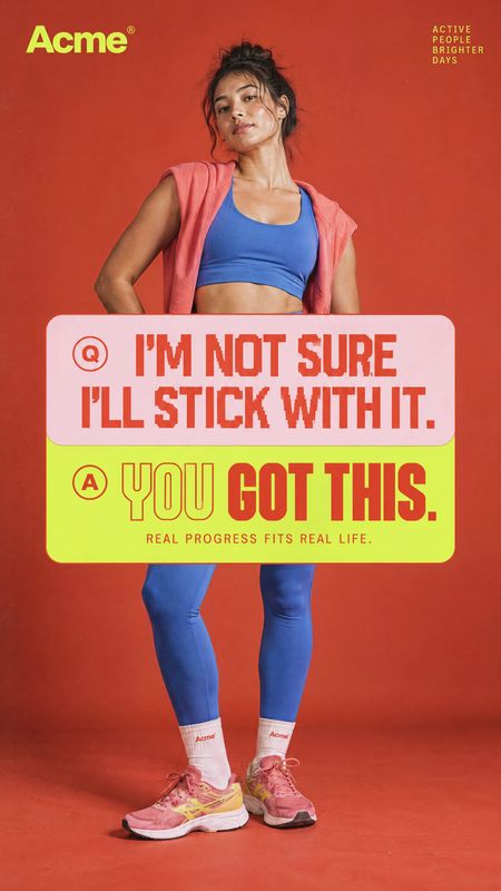 activewear and sneakers model try-on product photo: A woman in blue workout clothes, a coral jacket and pink sneakers poses against a vivid red studio backdrop…