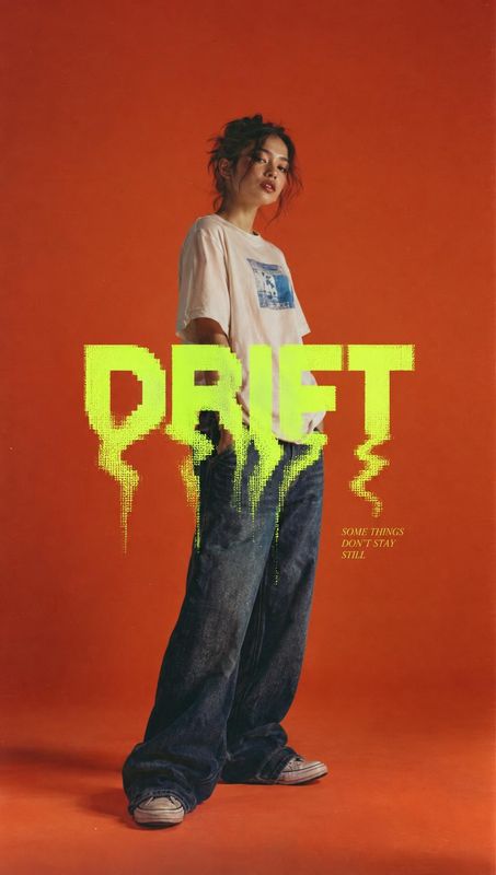 casual outfit posters product photo: A model in a white graphic T-shirt, oversized dark jeans and sneakers poses against a vivid orange studio backdrop beneath…