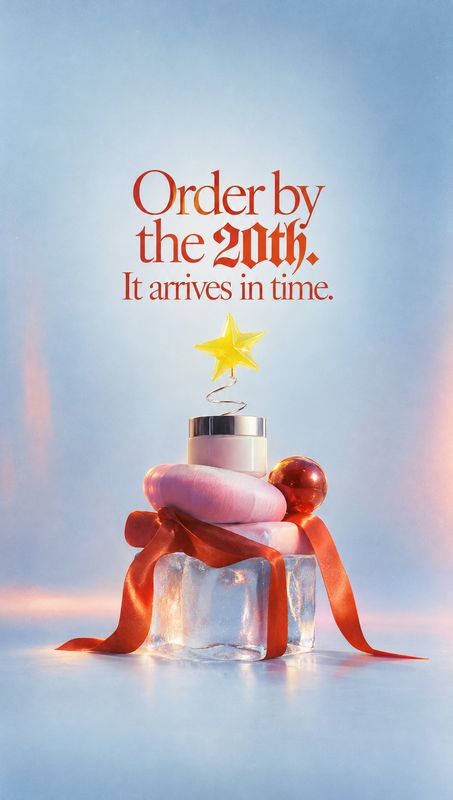 perfume bottle christmas product photo: A perfume bottle rests on an icy pedestal wrapped in a flowing red ribbon, with a gold star topper against a soft blue…
