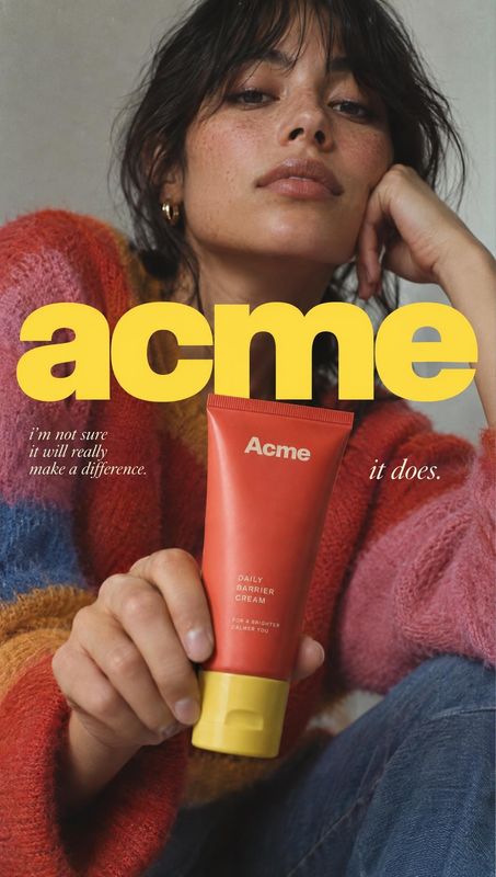 daily barrier cream beauty close-up product photo: A woman in a colorful knit sweater holds a red-and-yellow skincare cream tube toward the camera against a mu…