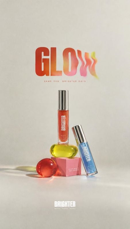lip gloss still life product photo: Colorful lip gloss tubes and spherical props are arranged on a pale studio surface beneath bold, playful lettering, with so…
