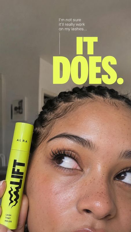 lash mascara beauty close-up product photo: A close-up of a woman showing her lashes while holding a bright lime mascara tube, with bold neon headline text aga…