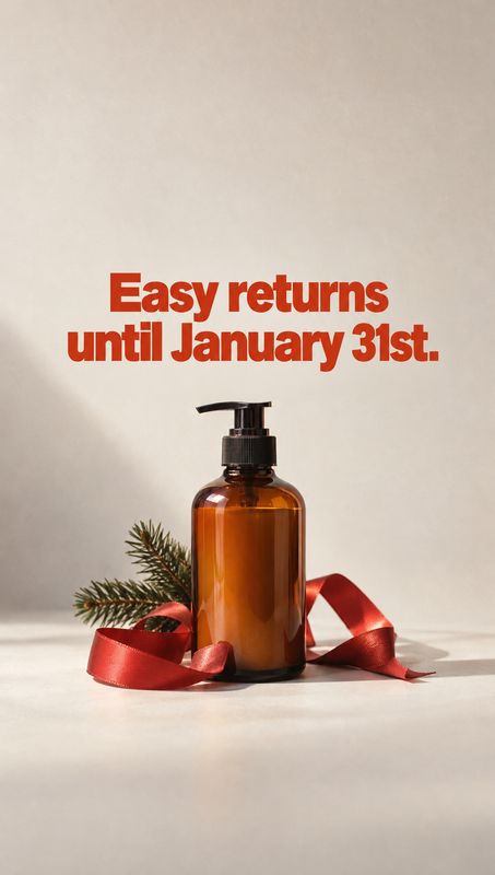 amber pump bottle christmas product photo: An amber pump bottle sits among a red ribbon and evergreen sprig on a pale studio surface, beneath bold red return-p…