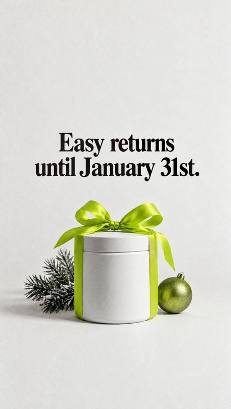 cosmetic cream jar christmas product photo: A white cosmetic jar tied with a bright green ribbon sits beside a frosted evergreen sprig and green ornament benea…