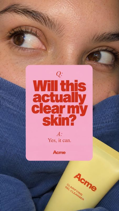 gel cleanser beauty close-up product photo: A close-cropped face in a blue sweater looks upward behind a yellow cleanser tube and a pink Q&A card, with bright,…
