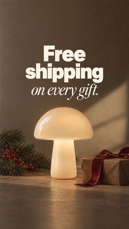 mushroom-shaped table lamp christmas product photo: A glossy cream mushroom-shaped lamp sits beside a wrapped gift and festive greenery on a tabletop, warmly l…