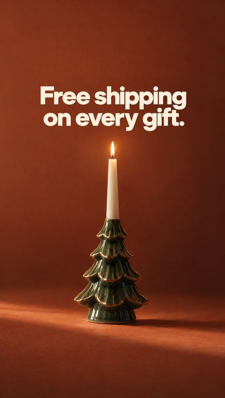 tree-shaped candle holder christmas product photo: A lit taper candle stands in a glossy green tree-shaped holder against a warm rust-colored studio backdrop,…