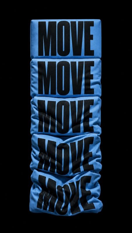 blue graphic shirts fashion product photo: A vertical stack of bright blue folded shirts printed with oversized black “MOVE” lettering sits against a deep blac…