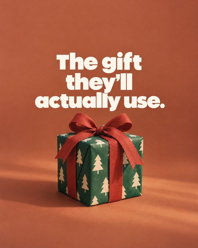 wrapped gift box christmas product photo: A green, tree-patterned gift box tied with a red ribbon sits against a warm terracotta studio backdrop beneath bold c…