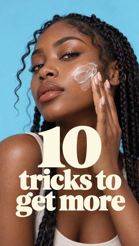 beauty close-up product photo: A close-up beauty portrait shows a woman with braided hair applying cream to her cheek against a bright blue studio backdrop, wi…