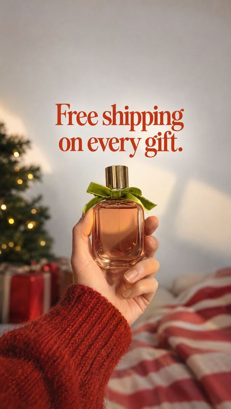 perfume christmas product photo: A hand in a red knit sleeve presents a perfume bottle tied with a green ribbon against a softly lit Christmas setting, with a…