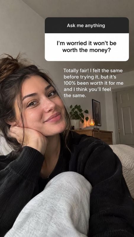 beauty close-up product photo: A woman in a black sweater poses casually in a softly lit bedroom, with a question sticker and reassuring response text overlaid…
