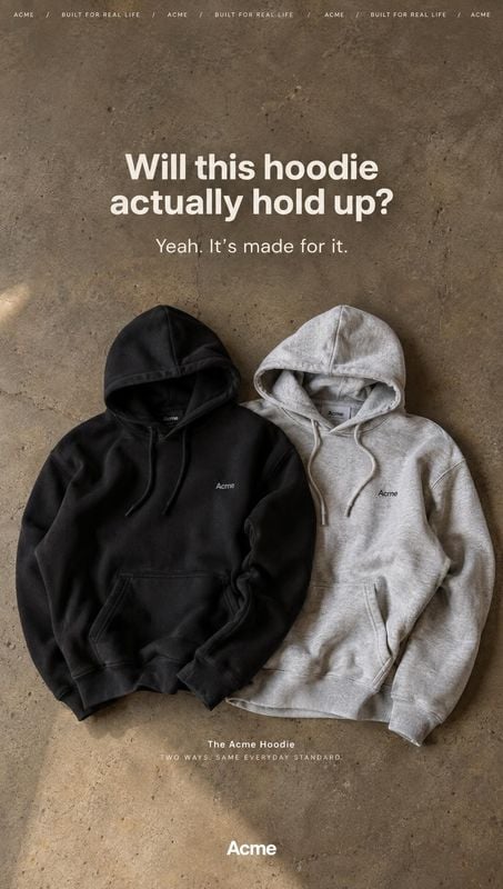 hoodies flat lay product photo: Two black and light-gray hoodies are arranged on a textured concrete surface beneath bold white promotional text, creating a ru…