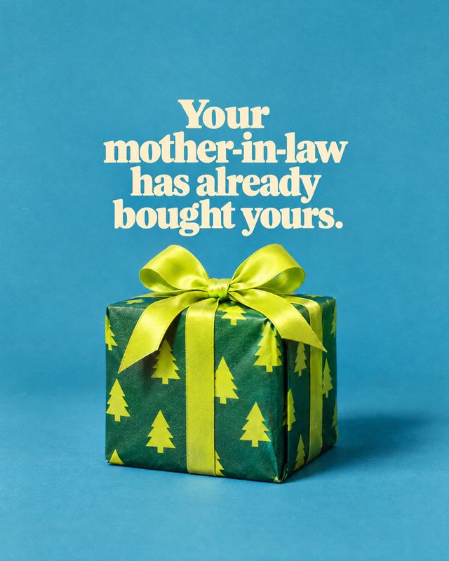 wrapped gift box christmas product photo: A green gift box patterned with bright yellow trees and tied with a glossy lime-green bow sits against a vivid blue s…