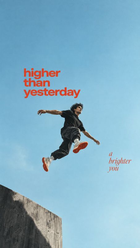 action & motion product photo: A man in dark streetwear and sneakers leaps above a concrete ledge against a bright blue sky, with bold red motivational typogra…