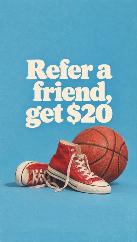 red sneakers still life product photo: Red high-top sneakers and a worn basketball sit on a bright blue studio backdrop beneath bold cream referral-offer typog…