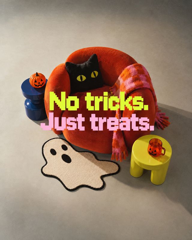 orange accent chair with coordinating decor halloween product photo: A vivid orange chair, pink scarf, playful ghost rug, and small side tables create a Hallow…