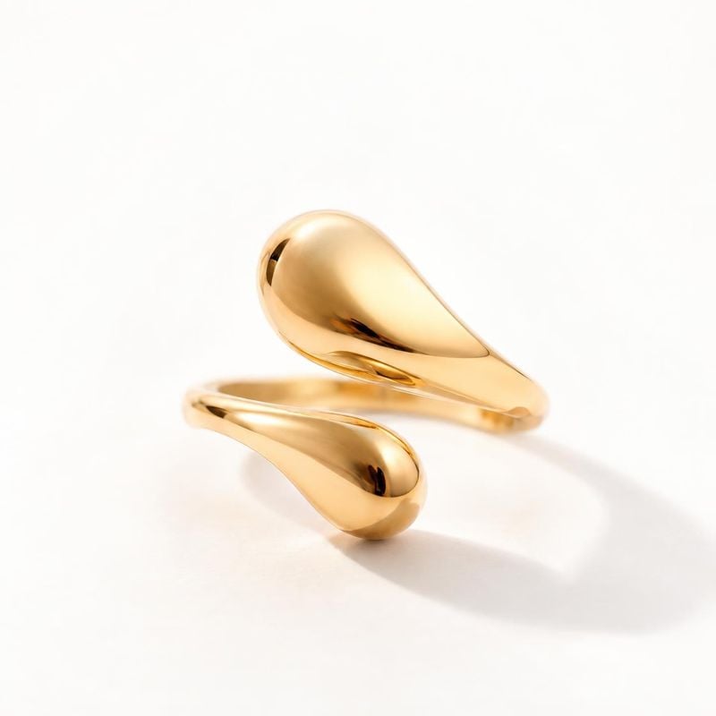 gold sculptural ring jewelry product photo: A polished sculptural gold ring is isolated against a bright white studio background, with soft shadows and generou…