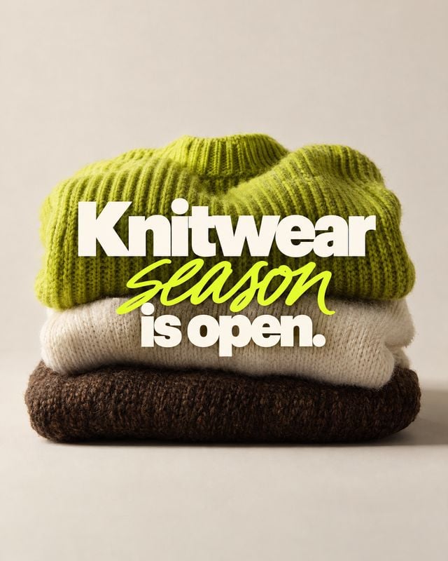 folded knitwear autumn product photo: A neatly stacked pile of chunky knit sweaters in lime green, cream, and dark brown sits against a warm neutral studio bac…