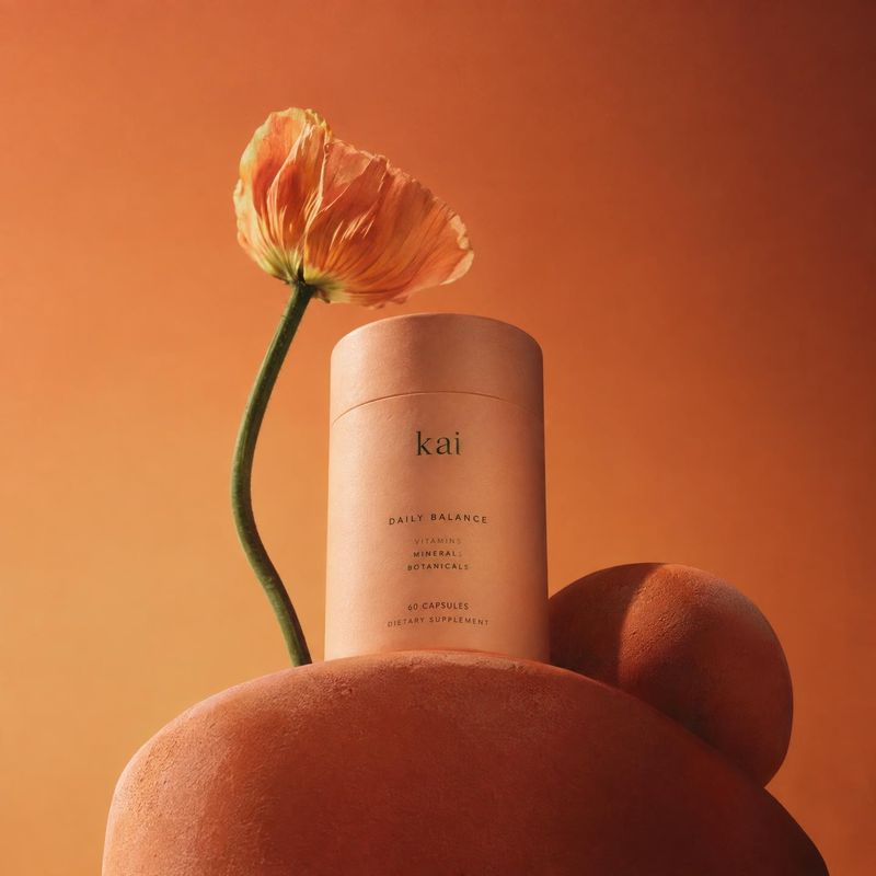 dietary supplement capsules personal care product photo: A peach-toned supplement canister is artfully arranged with a poppy and sculptural forms against a war…