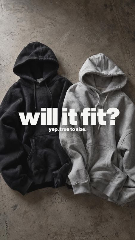 hoodies flat lay product photo: Two black and light-gray hoodies are arranged side by side on a weathered concrete surface, with bold white sizing copy across…