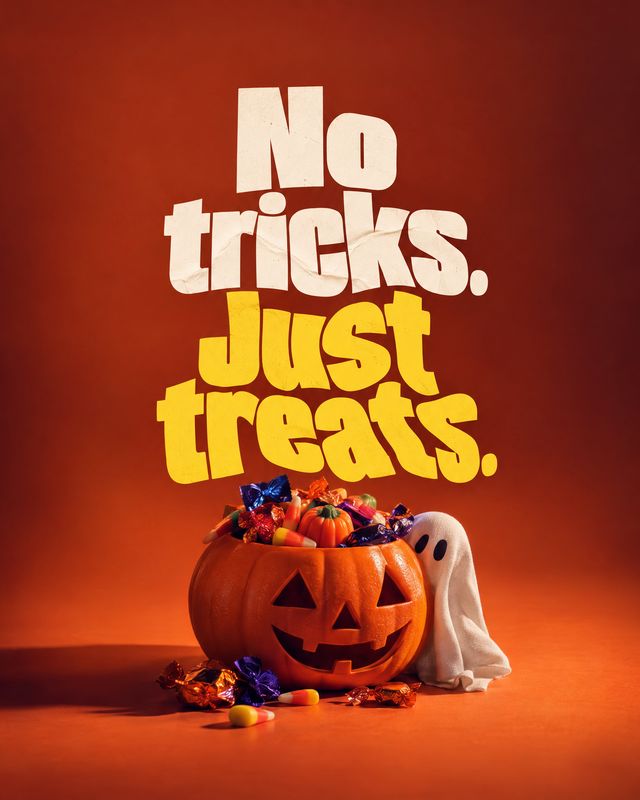 Halloween candy halloween product photo: A jack-o'-lantern overflowing with wrapped Halloween candy and a small ghost prop sits on an orange studio set beneath…
