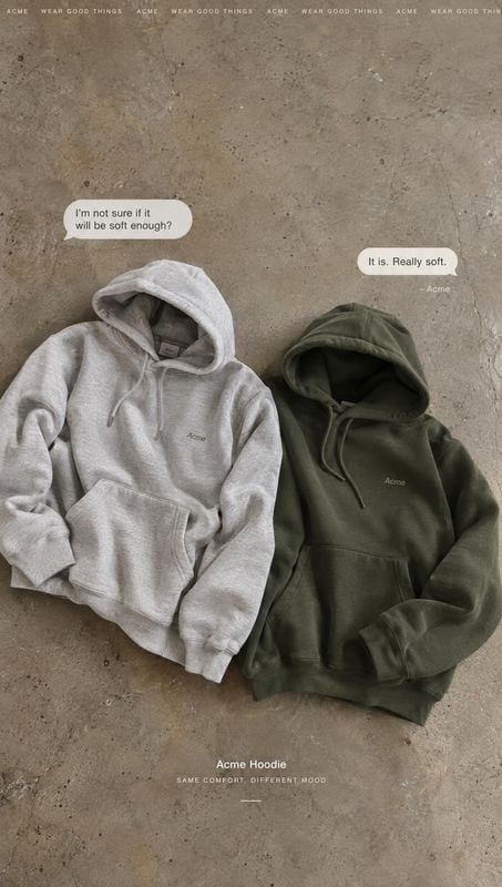 hoodies flat lay product photo: Two hoodies in light gray and olive are arranged on a textured concrete surface, with soft natural-looking light and a muted, c…