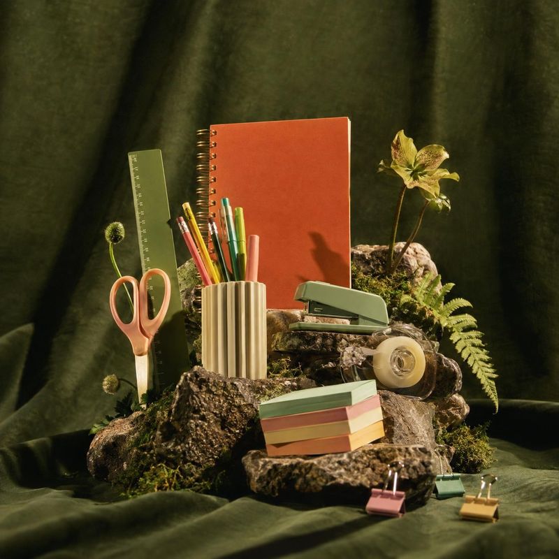 stationery set stationery product photo: A carefully arranged collection of colorful stationery—including a notebook, pens, scissors, tape, and clips—rests amo…