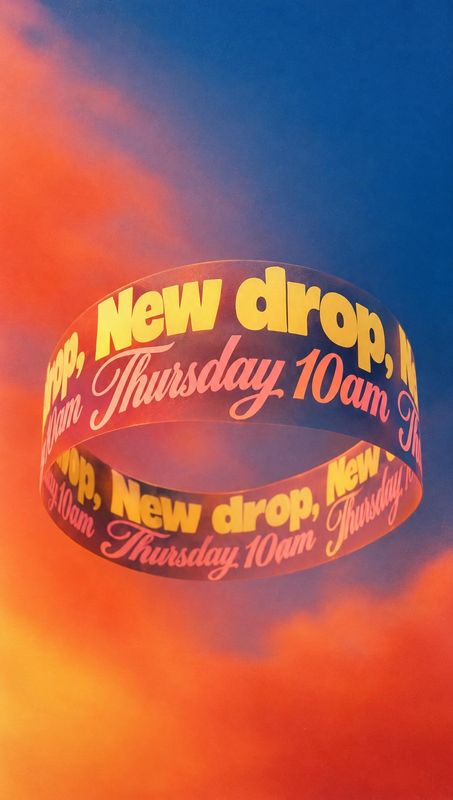 floating product product photo: A floating loop of bold yellow and pink lettering announces a new drop on Thursday against a vivid blue-and-orange cloudy backg…