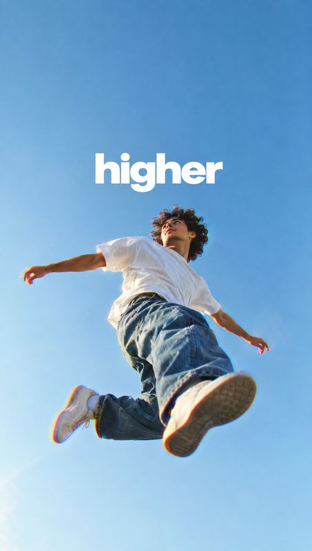 sneakers action & motion product photo: A young man in a white T-shirt, loose jeans and sneakers leaps against a clear blue sky, with bold white “higher” lette…