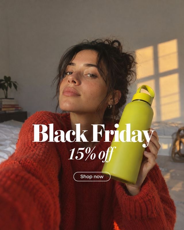 reusable water bottle sports product photo: A woman in a chunky red sweater holds a bright lime-green reusable bottle in a softly lit bedroom, with warm window…