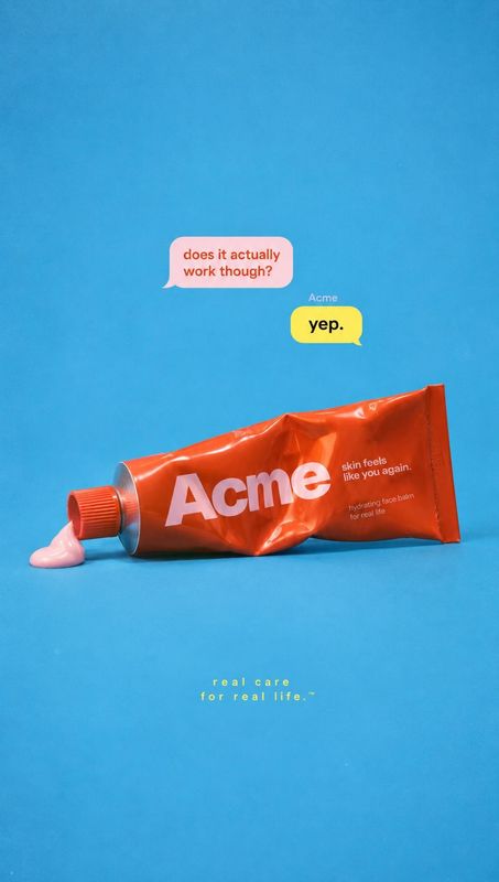 moisturizer tube packshot product photo: A glossy orange moisturizer tube with a dab of pink cream rests on a bright blue studio surface beneath playful chat b…