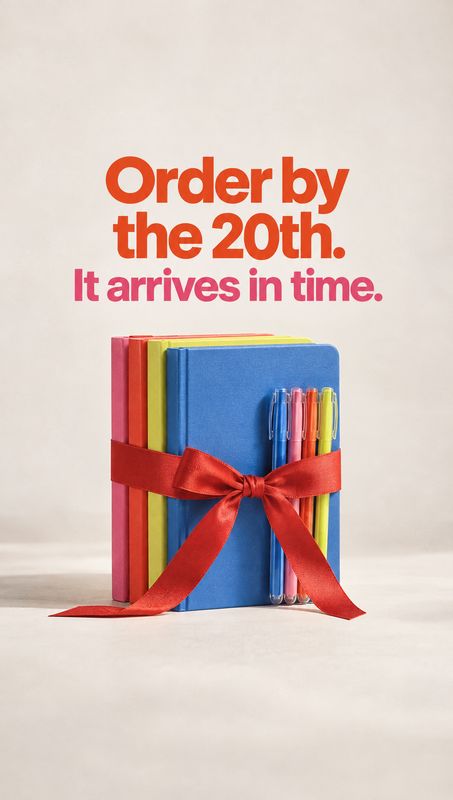 notebooks and pens stationery product photo: Colorful notebooks and pens tied with a red ribbon sit against a soft neutral studio backdrop beneath bold orange…