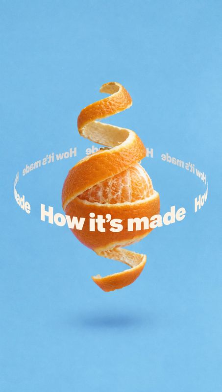 orange floating product product photo: A peeled orange floats against a bright blue background, encircled by bold white “How it’s made” lettering for a playful…