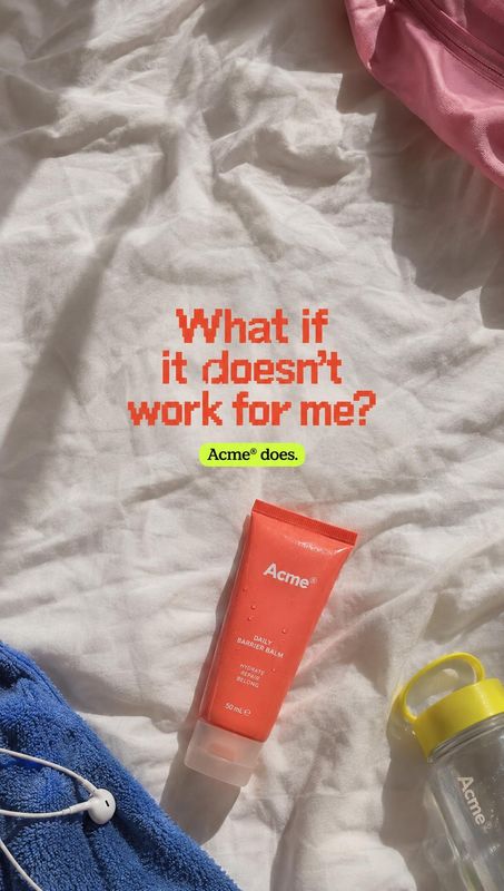 barrier balm flat lay product photo: An orange balm tube lies among colorful personal-care items on rumpled white bedding, with bold red reassurance text and s…