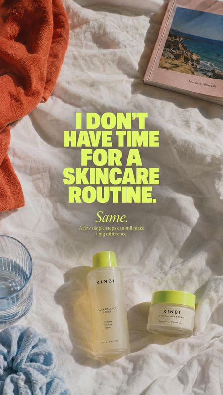skincare products flat lay product photo: Skincare bottles and jars with bright green caps rest on rumpled white bedding among a rust-colored towel and a book,…
