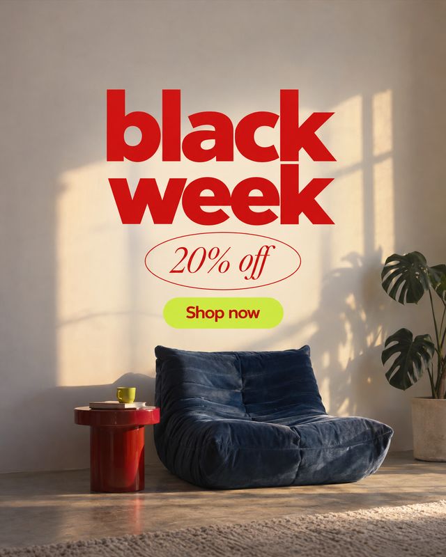 blue lounge chair room set product photo: A plush navy lounge chair sits beside a red side table and leafy plant in a sunlit minimalist interior, beneath bold…