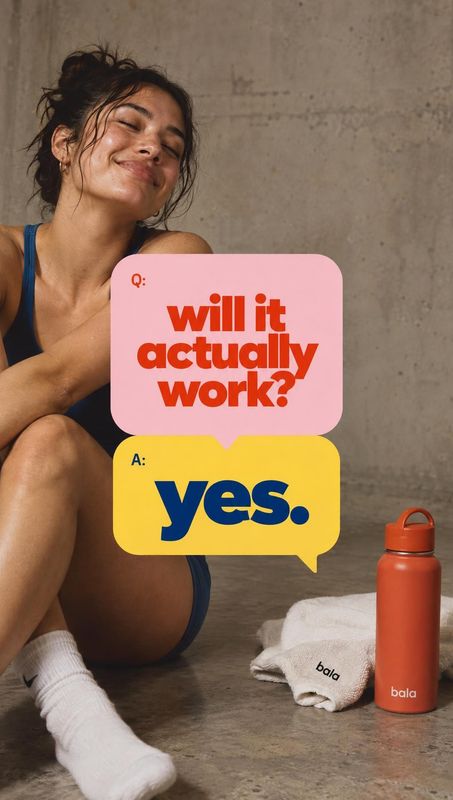 orange reusable water bottle lifestyle scene product photo: An athletic woman in dark workout clothes sits on a concrete studio floor beside an orange Bala bot…