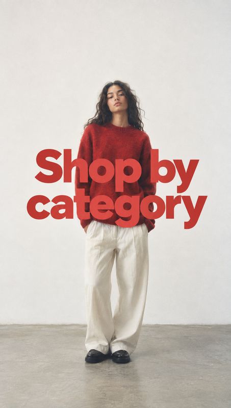 outfit black friday product photo: A model in a red sweater, loose white trousers, and black shoes stands against a pale studio wall, overlaid with bold red “S…